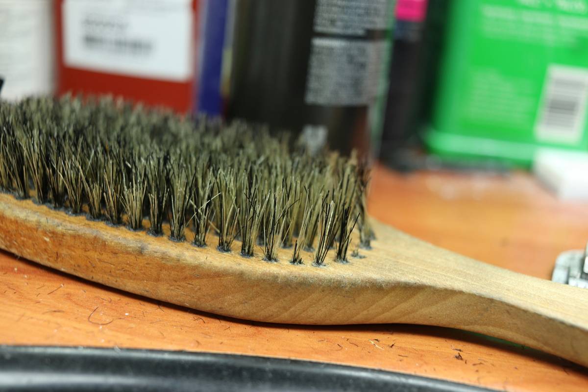 Woman gently using a detangling hair brush on wet, curly hair to prevent breakage